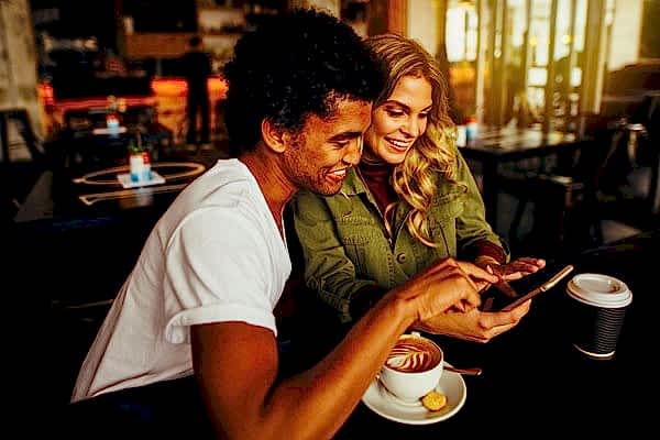 Friends-sharing-referrals-on-smarthpone-while-drinking-coffee