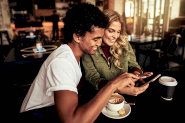 Friends-sharing-referrals-on-smarthpone-while-drinking-coffee